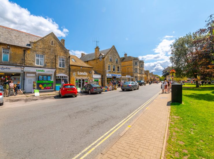 A busy summer day along the main shopping area, High Street at Bourton-on-the-Water, a village in the rural Cotswolds area of south central England.